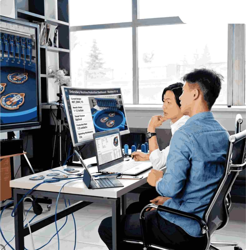 Designer working at a workstation with custom patch samples and dual monitors.